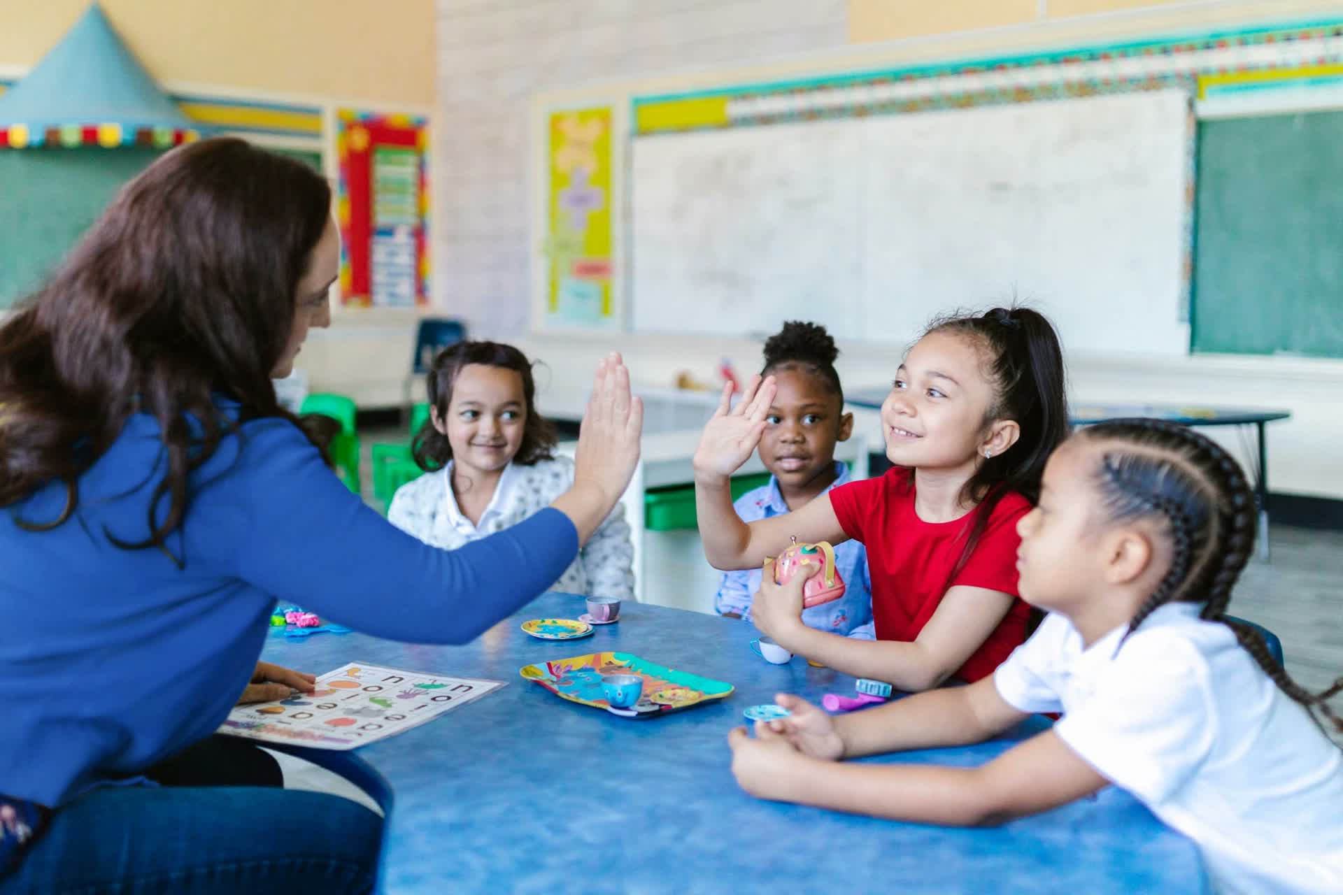 Teacher with diverse school children engaged in learning around her