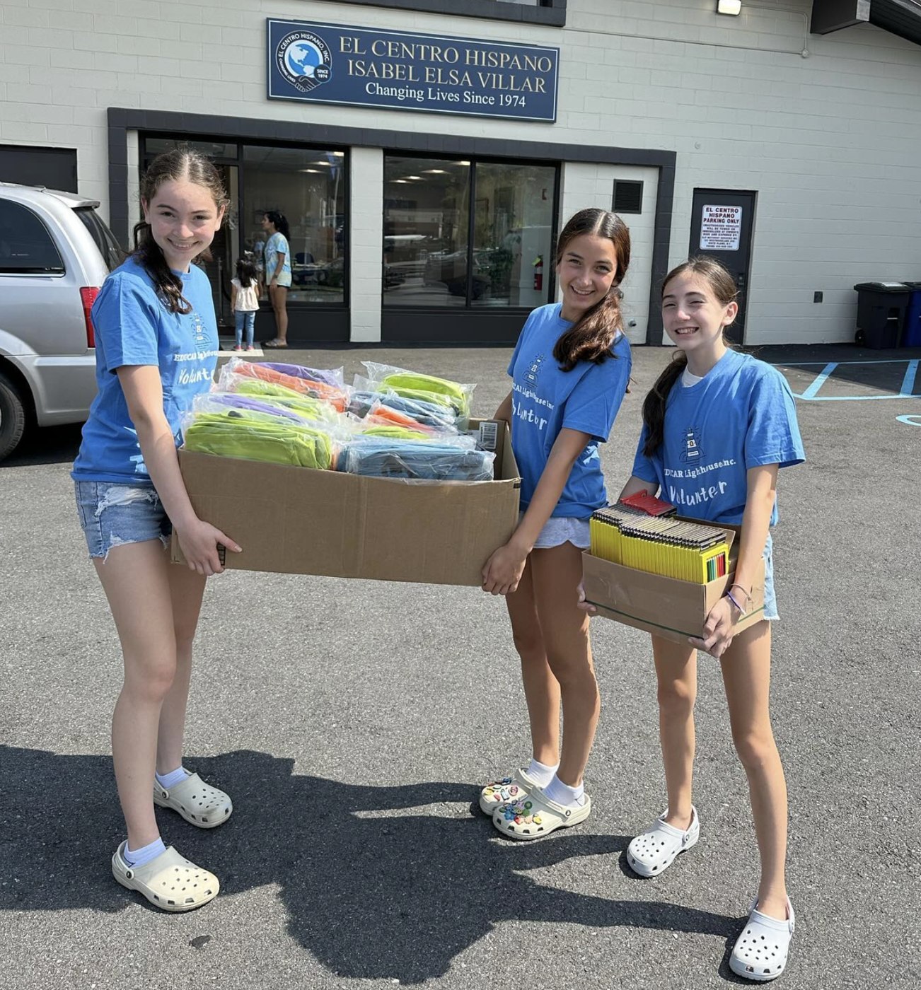 Volunteers delivering boxes of school supplies at El Centro Hispano